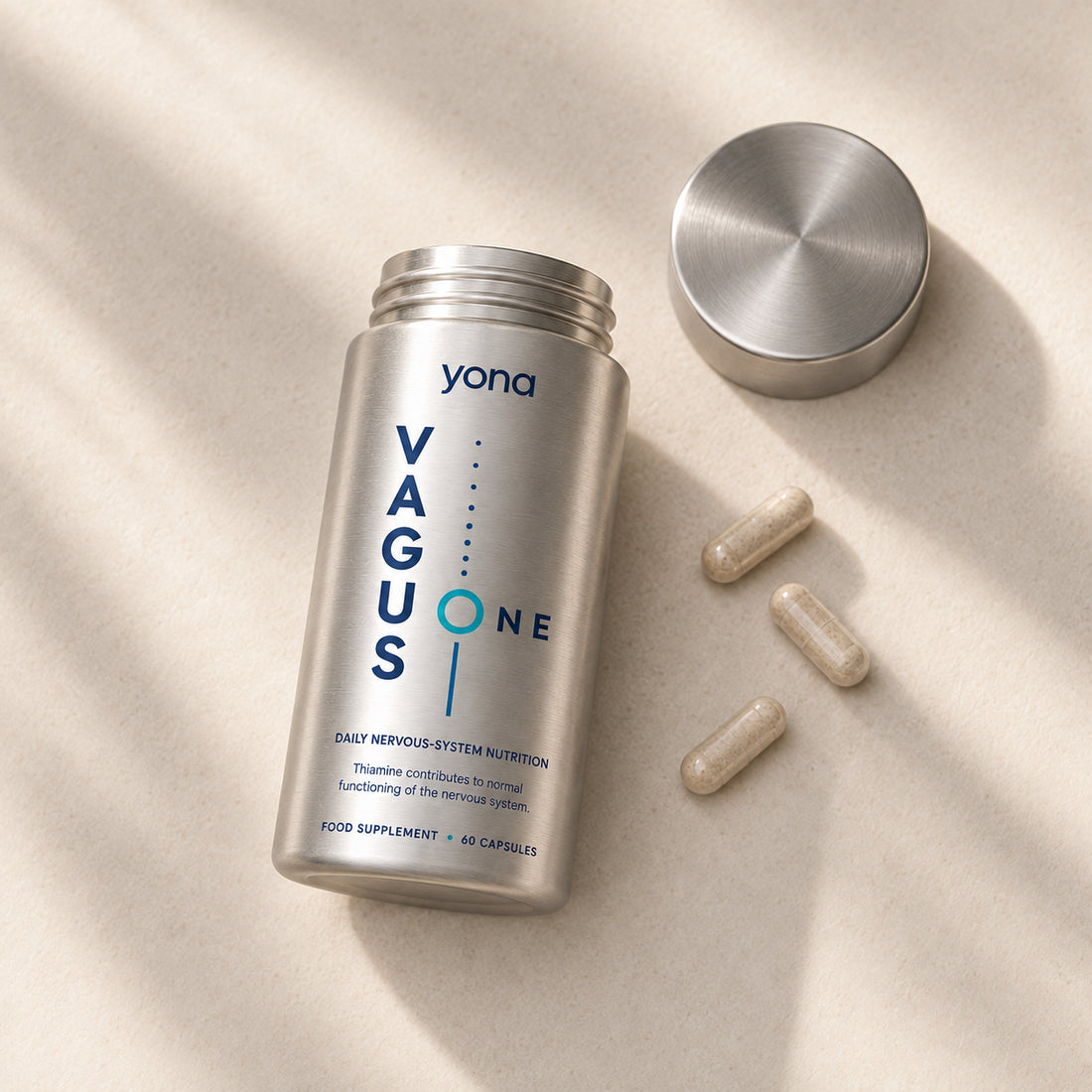 An open Vagus One bottle with its lid and three capsules beside it.